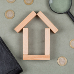 real-estate-financial-concept-with-wooden-blocks-magnifying-glass-notebook-coins-grey-background-close-up_176474-7845